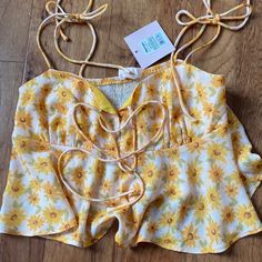 Tie Up Flowy Cropped Tank With Yellow Floral Pattern. Never Worn New With Tags Boutique Blouse Sleeveless Tops With Lemon Print For Vacation, Cute Yellow Summer Tops, Vacation Sleeveless Tops With Lemon Print, Lemon Print Summer Tops, Summer Vacation Tops With Lemon Print, Mustard Floral Print Summer Top, Yellow Floral Print Top For Spring, Spring Yellow Floral Print Top, Sunflower Print Beach Tops For Summer