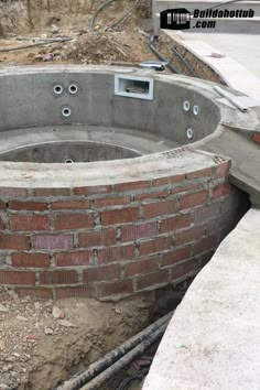 an outdoor hot tub built into the side of a brick building with pipes running through it