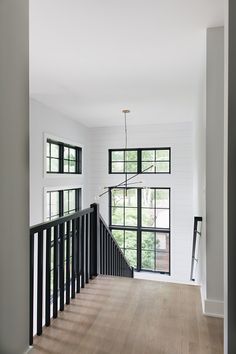 an empty room with wooden floors and black railings