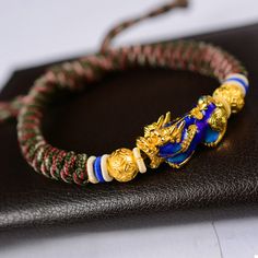 The Pi Xiu bracelet "Wealth and Abundance", carefully hand braided, is adjustable according to the size of your wrist thanks to its sliding thread system. Chic and easy to wear, this 24K gold-plated Pi Xiu protection bracelet will be an original and quality set for your wrist. ABOUT PI XIU This celestial animal is pronounced as “Pixiu” in Chinese. It is a mythical god beast in Chinese mythology, embodied with a dragon head, horse body and qilin’s feet, similar to a lion. Besides that, it has a b Gold Bracelets With Adjustable Chain For Festival, Spiritual Braided Bracelet Jewelry, Adjustable Braided Bracelet Jewelry, Adjustable Braided Jewelry Bracelet, Gold Friendship Bracelets With Sliding Knot For Festivals, Adjustable Gold Friendship Bracelets For Festivals, Adjustable Gold Friendship Bracelet For Festivals, Gold Beaded Bracelet With Adjustable Cord For Festival, Gold Beaded Bracelets With Adjustable Cord For Festival