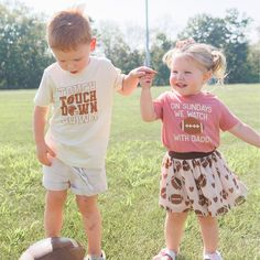 The Touchdown Echo Short Sleeve T-Shirt is a fun and handsome t-shirt for kids celebrating Game Day! Features: Shirt Color: Natural Graphic Color: Brown Material: 100% Cotton Features: Tagless inside neck label for an itch-free wear Fit: Toddler Unisex; True to Size Care: Machine washable, tumble dry low, wash with like colors Each t-shirt is hand pressed with love in our hometown warehouse. Cute Short Sleeve T-shirt For Game Day, Playful Summer T-shirt For Playdate, Family Matching Game Day Tops With Short Sleeves, Funny Short Sleeve Tops For Playtime, Family Matching Cotton T-shirts For Game Day, Fun Screen Print Tops For Game Day, Fun Game Day Top With Screen Print, Family Matching Short Sleeve Tops For Playwear, Family Matching Cotton Tops For Game Day