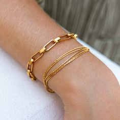 Grace your wrist with the Windswept Bracelet, a multi-strand piece that flows like a gentle breeze. Delicate rectangle box chains embody the fluidity of air, allowing you to carry its tranquil energy with you. The multi-strand design mimics the subtle changes of the wind, a symbol of unbridled freedom. 18K Gold-Plated Stainless Steel Nickel-Free Lead-Free Hypoallergenic Water Resistant Modern Double Chain Bracelet For Everyday, Modern Double Chain Bracelet As Gift, Modern Chain Bracelet With Rectangular Links And Extender, Adjustable Rectangular Box Chain Bracelet, Rectangular Box Chain Bracelet, Adjustable Multi-strand Bracelet As Gift, Modern Chain Bracelet With Extender As Gift, Adjustable Multi-strand Chain Bracelet Gift, Elegant Multi-strand Bracelets For Everyday