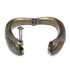 *Description: This is a great embossed design tribal bracelet with a hinge and plunger clasp which makes it very easy to take on and off from the 1940s. The plunger stays attached so you don't have to worry about loosing it. The bracelet has a gold wash, which I tested at 10K gold surface metal. The bracelet under the gold wash is a non-magnetic brass metal; probably mostly hollow. The shape of the bracelet is very unique and is more of a triangular shape with the flat portion on the bottom behi Antique Hinged Cuff Bracelet Bangle, Antique Hinged Cuff Bracelet, Antique Hinged Bangle Cuff Bracelet, Vintage Ceremonial Bangle With Antique Finish, Vintage Bronze Ceremonial Bangle, Ceremonial Vintage Bronze Bangle, Vintage Carved Bracelets For Ceremonial Occasions, Antique Metal Cuff Bracelet With Engraving, Vintage Engraved Bracelets For Ceremonial Occasions