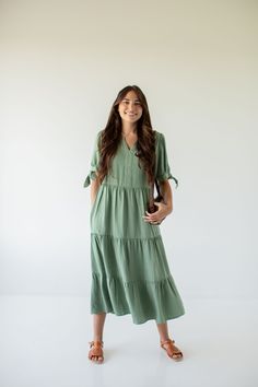 Add a pop of color with the "Kaia' midi dress! This midi dress features tie sleeves and a tiered silhouette, creating a flattering and comfortable ensemble. Pair with sandals and a shoulder bag for a charming and sophisticated vacation look! 100% Lyocell Unlined Machine Wash Cold Hang Or Lay Flat Do Not Bleach  Cool Ir Modest Flowy Tiered Dress For Summer, Modest Flowy Tiered Summer Dress, Flowy Modest Tiered Summer Dress, Spring Maxi Dress With Ruffle Hem, Spring Tiered Skirt Maxi Dress For Brunch, Summer Vacation Tiered Midi Dress, Flowy Tiered Midi Dress Casual Style, Flowy Tiered Midi Dress Casual, Flowy Tiered Casual Midi Dress