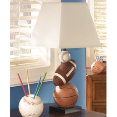 a lamp that is sitting on top of a table next to a baseball and ball