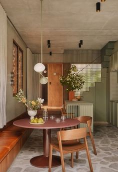 a dining room table with chairs and vases on it