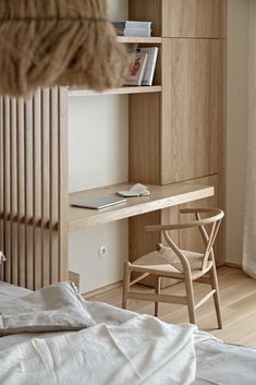 a bedroom with a bed, desk and bookshelf next to a wall mounted bookcase