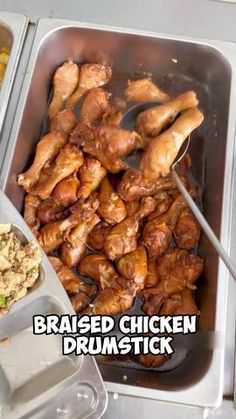 chicken drumsticks are being cooked and served in trays with other food on the side