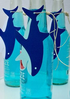 three blue bottles with dolphins on them sitting next to each other