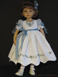 a doll wearing a white dress and blue bow