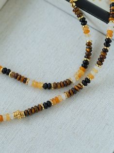 Elevate your style with a variety of natural stone beaded necklaces, including Tiger's Eye and Black Onyx, featuring an orange natural stone that is reminiscent of orange soda, adding a touch of coolness to hot summer days. This stunning piece perfectly combines Tiger's Eye with a variety of complementary beads to create a rich and vibrant accessory designed to highlight your personality and enhance your natural beauty. Metal: 18K Recycled Gold Plated On Brass Gemstone: Tiger's Eye/Multi Stone Length: 370-470mm Weight: 15g Orange Bohemian Crystal Necklace With Natural Stones, Bohemian Orange Crystal Necklace With Natural Stones, Brown Gemstone Beads Necklace For Beach, Orange Beaded Necklaces With Natural Stones In Spiritual Style, Adjustable Gemstone Beaded Necklace For Beach, Orange Spiritual Beaded Necklace With Natural Stones, Spiritual Orange Beaded Necklace With Natural Stones, Bohemian Adjustable Orange Crystal Necklaces, Adjustable Bohemian Orange Crystal Necklaces