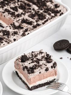 a piece of oreo cookie ice cream cake on a plate with a fork next to it