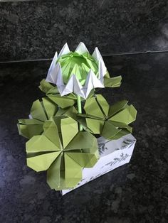 an origami flower in a box on a table