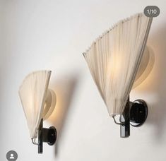 two lights that are on the wall next to each other, one is white and the other is black