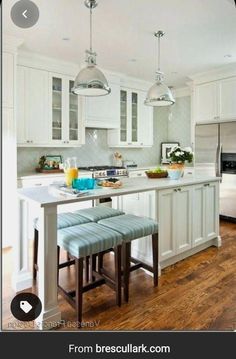 a kitchen with white cabinets and wooden floors