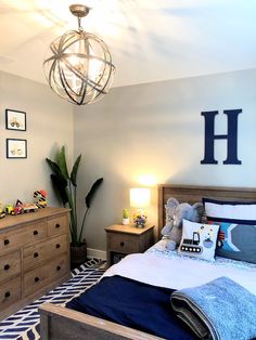 a bed room with a neatly made bed next to a night stand and dressers