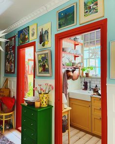 the kitchen is decorated in bright colors and has pictures on the wall above the sink