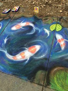 the sidewalk is painted with chalk and has koi fish on it