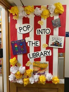 a library bulletin board with yellow flowers and pop into the library