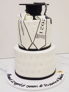 a graduation cake is decorated with white fondant and black trim