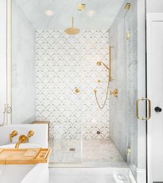 a white and gold bathroom with an open shower