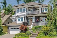 a large house with lots of trees and bushes around it's front entrance area