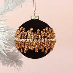 a black and gold ornament hanging from a christmas tree