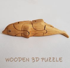 a wooden puzzle piece shaped like a fish on a white background with the words wooden 3d puzzle