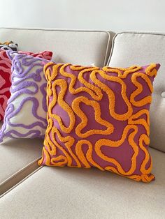 three decorative pillows are sitting on a couch