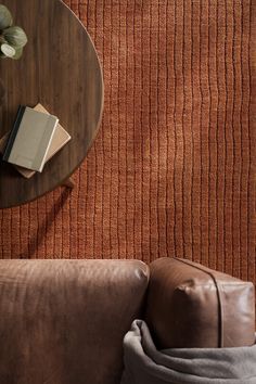 a table with a book on top of it next to a brown couch and chair