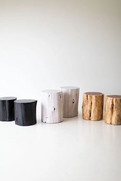 four wooden stools sitting next to each other on a white surface