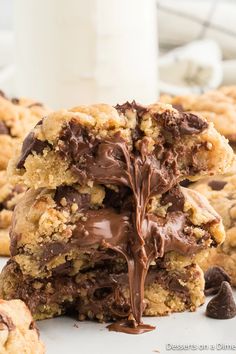 chocolate chip cookies stacked on top of each other with one broken in half and the rest partially eaten