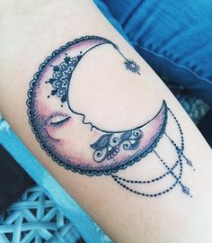 a woman's arm with a tattoo on it that has a crescent moon and stars