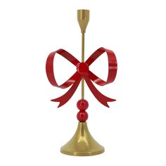 a bell with a red bow on it and a candle holder in the shape of a heart