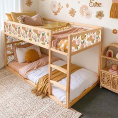 a child's bedroom with bunk beds and decorations on the wall, including flowers