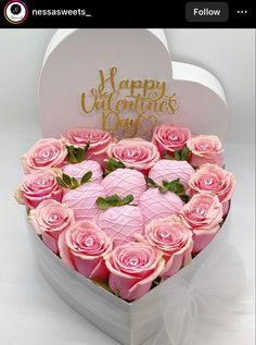 a heart shaped box filled with pink roses