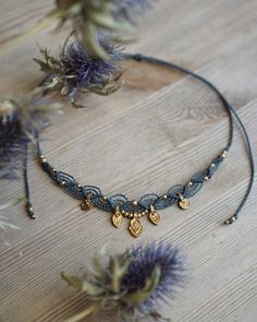 a necklace with two charms hanging from it's side on top of a wooden table