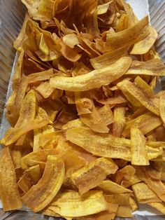 a pile of potato chips sitting on top of a piece of tin foil in a container