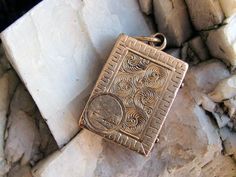 a gold pendant sitting on top of some rocks