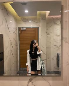 a woman taking a selfie in front of a mirror