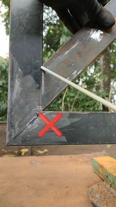 a person holding a knife in front of a metal object with a red x on it