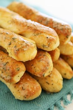 there is a pile of breadsticks that are sitting on a blue cloth with some seasoning sprinkled on them