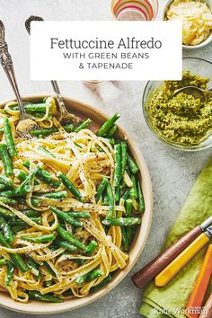 a bowl filled with pasta, green beans and pesto on top of a table