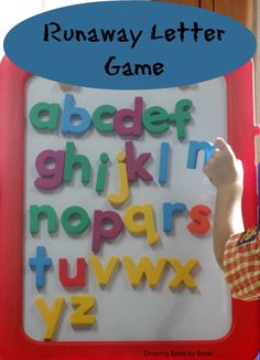 a young boy writing letters on a white board