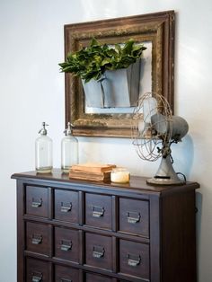 an old dresser has a fan on top of it