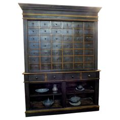 an old wooden cabinet with many dishes on it