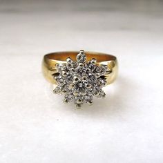 This is a beautiful vintage 14K diamond cluster cocktail ring.  The band is yellow gold, 5.9mm wide and sized between a 6 3/4 and a 7.  There are 18 round 2.1mm diamonds set into the cluster (.54tcw) with overall H color and SI1-SI2 clarity.  The very center 3.6mm round (0.19ct) diamond has H color with I1 clarity.  Total weight of the ring is 8.0 grams.  All stones are secure.   This is a vintage, previously owned ring.  Therefore, light wear can be expected.  There is no visible damage. Cluster Engagement Ring, Fabulous Jewelry, Dreamy Wedding, Pretty Rings, Ruby Ring, Diamond Cluster, Cluster Ring, Cocktail Ring, Cocktail Rings