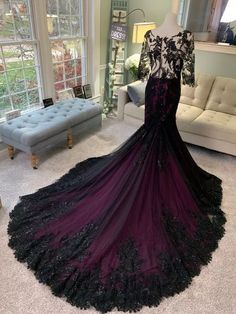 a black and purple dress is on display in a room with couches, pillows and windows