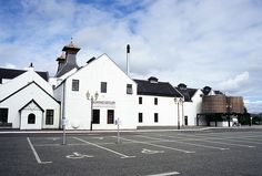 an empty parking lot in front of a white building