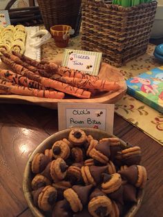 a bowl full of carrots and nuts on a table with other items in the background